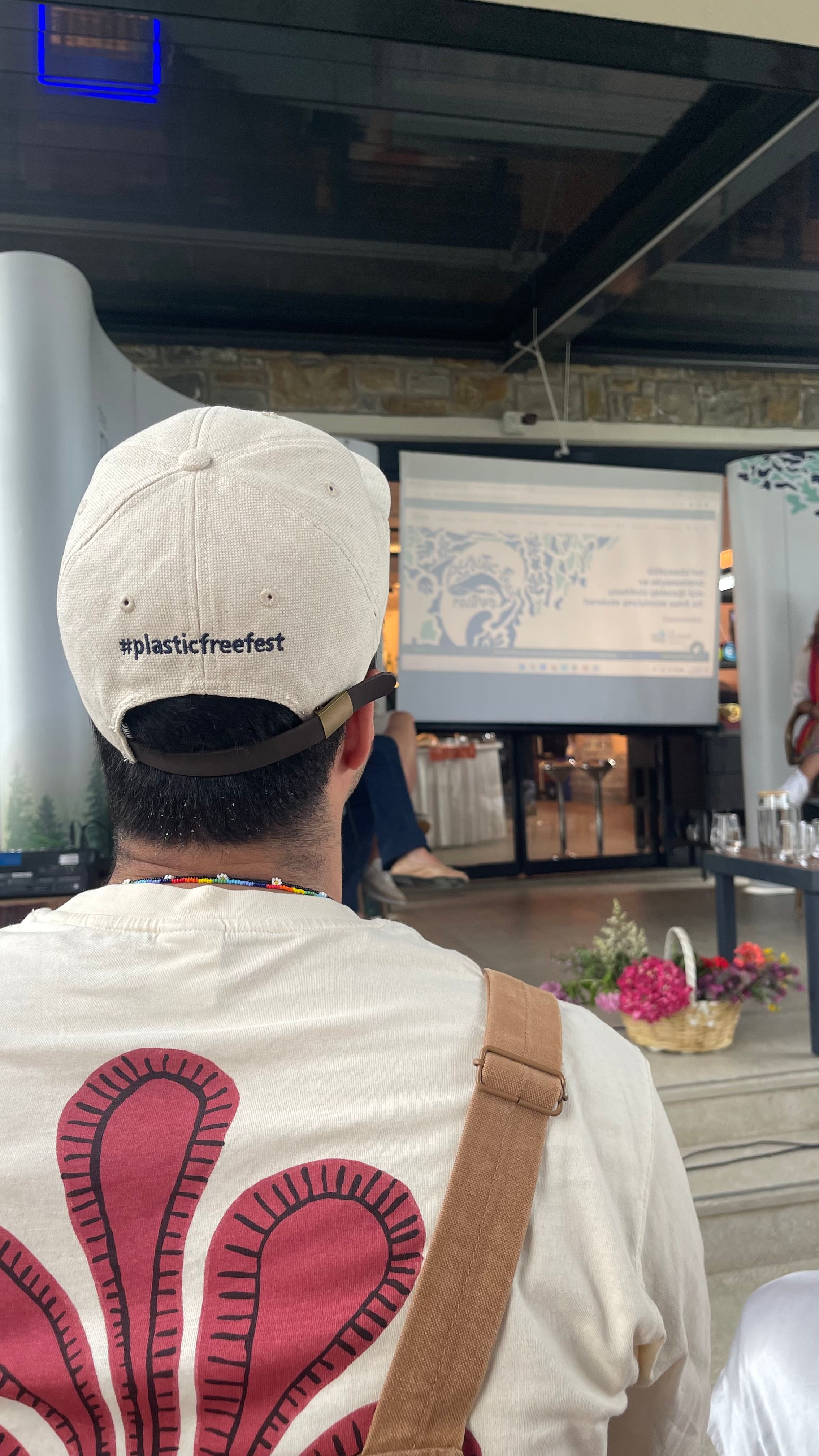 #plasticfreefest şapkalı katılımcı sunumu izliyor