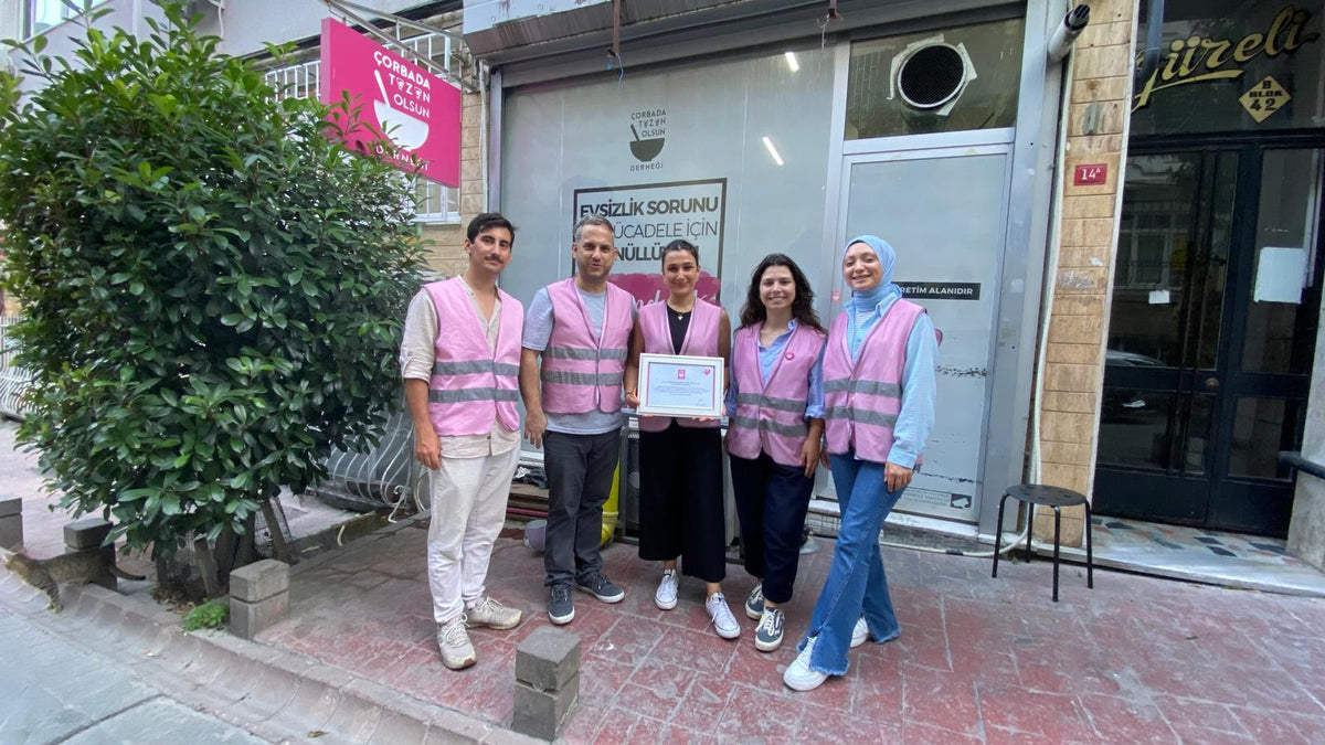 Çorbada Tuzun Olsun Derneği kapısı önünde plaketle beş gönüllü